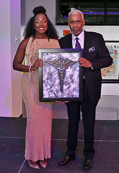 Harlem Fine Arts Show Founder, Dion Clark, presents Ashira Blazer, MD, with the “Art of Healing