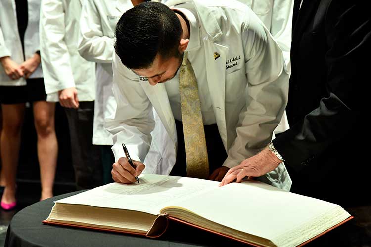Medical student signing a book
