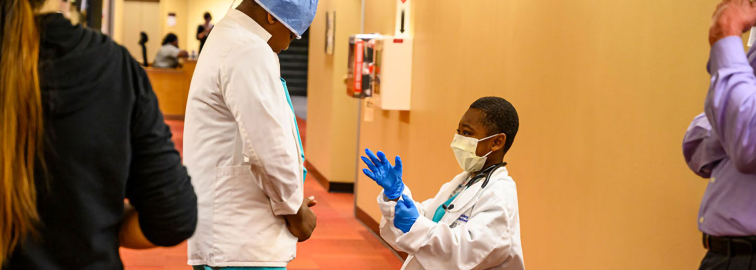 Doctor listening to young kid who dressed as a doctor